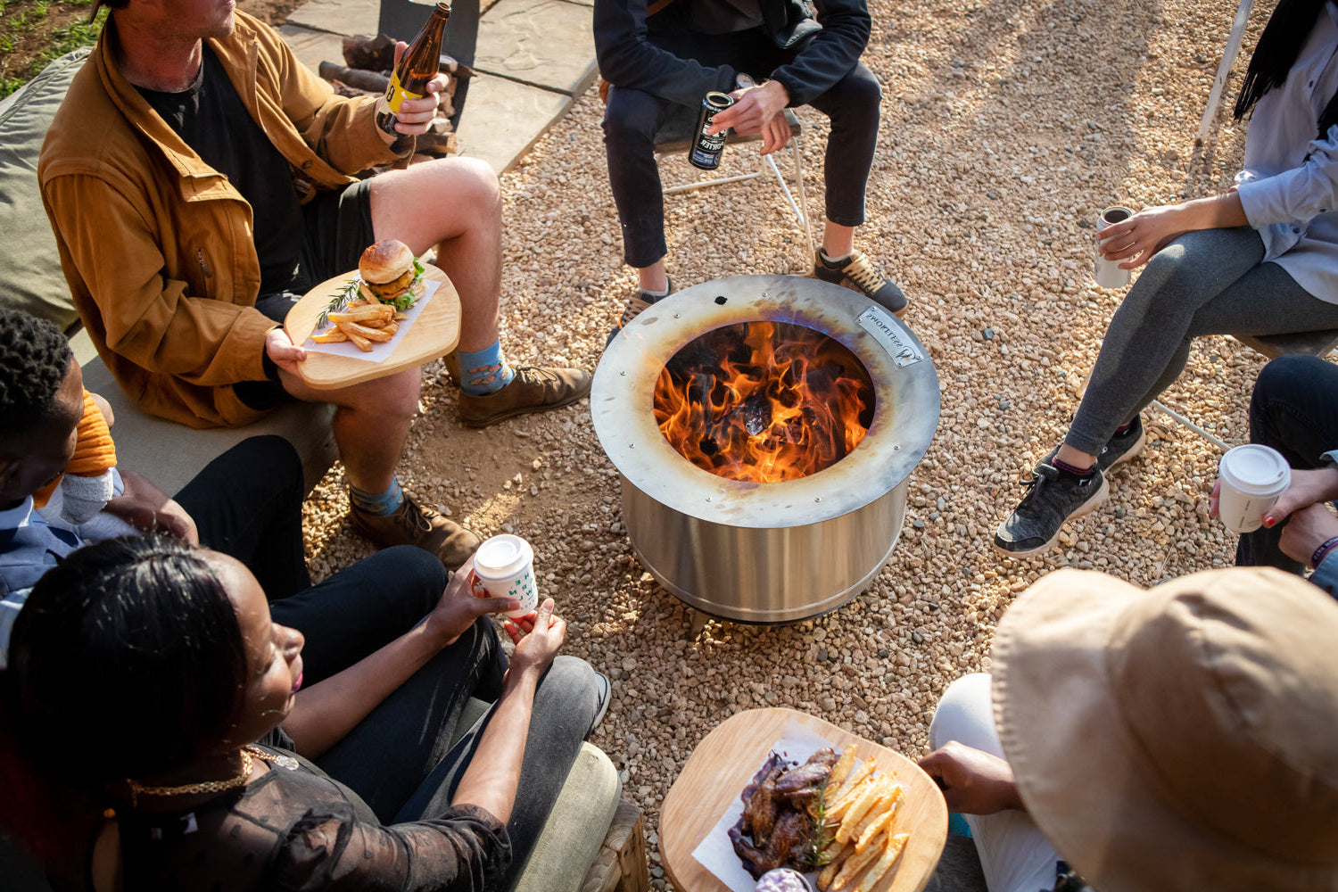 Friends enjoying lunch around a smokeless firepit