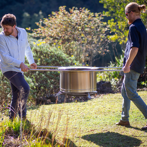 People using Stainless Steel Poles to move a Smokeless Fires firepit